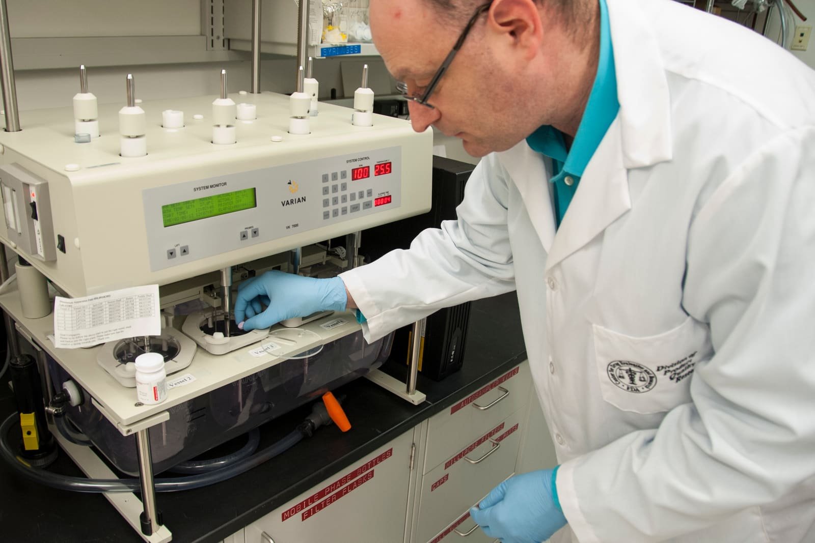 Analista de laboratório operando instrumento de bancada.