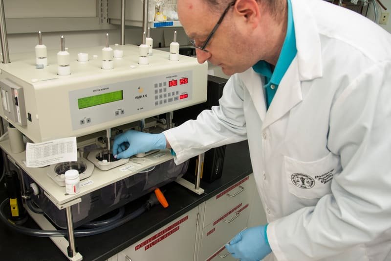 Analista de laboratório operando instrumento de bancada.
